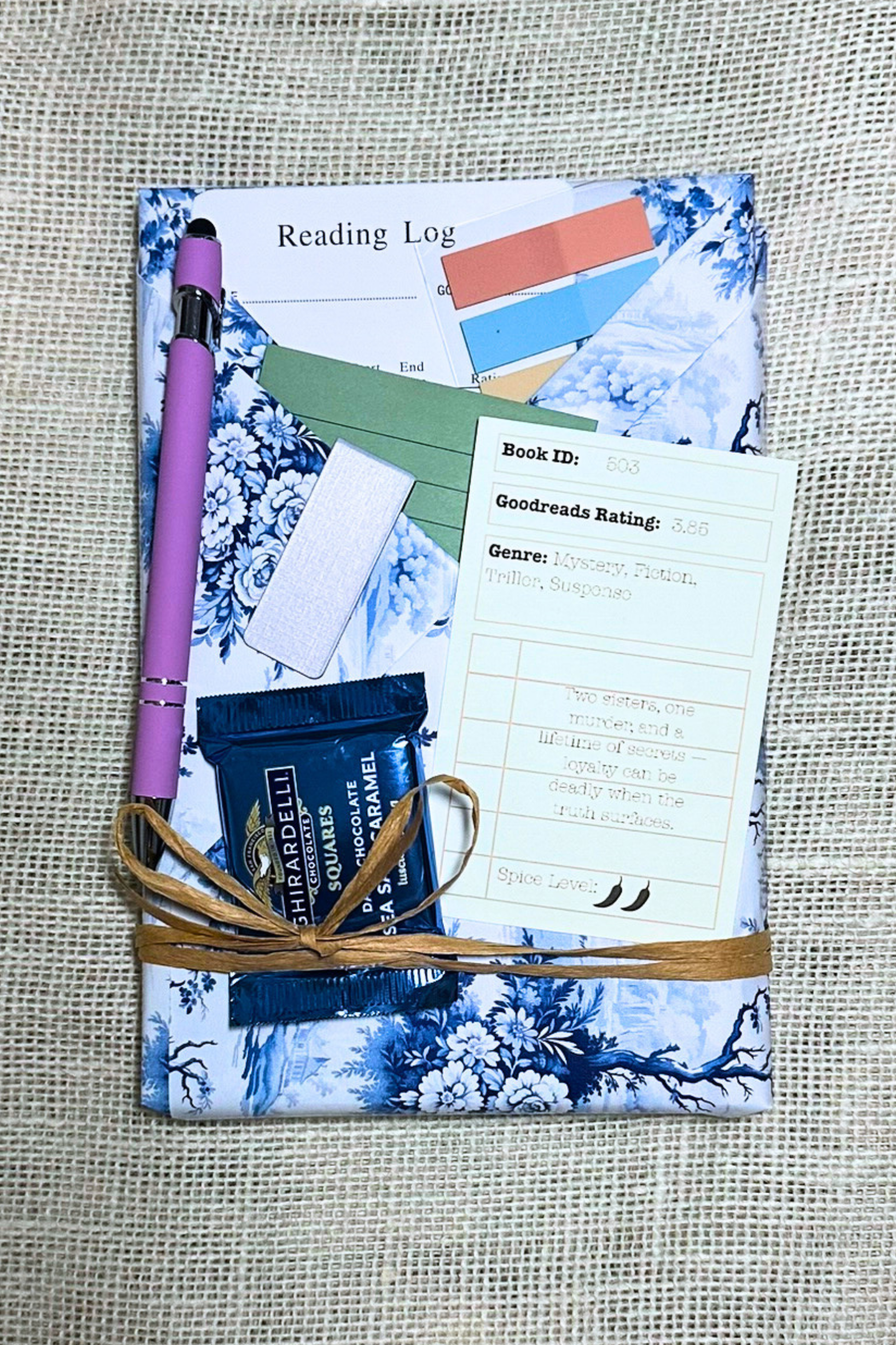 Wrapped book with pockets with book accessories inside. Including bookmark, pen, sticky notes, book tabs, and magnetic bookmark. 