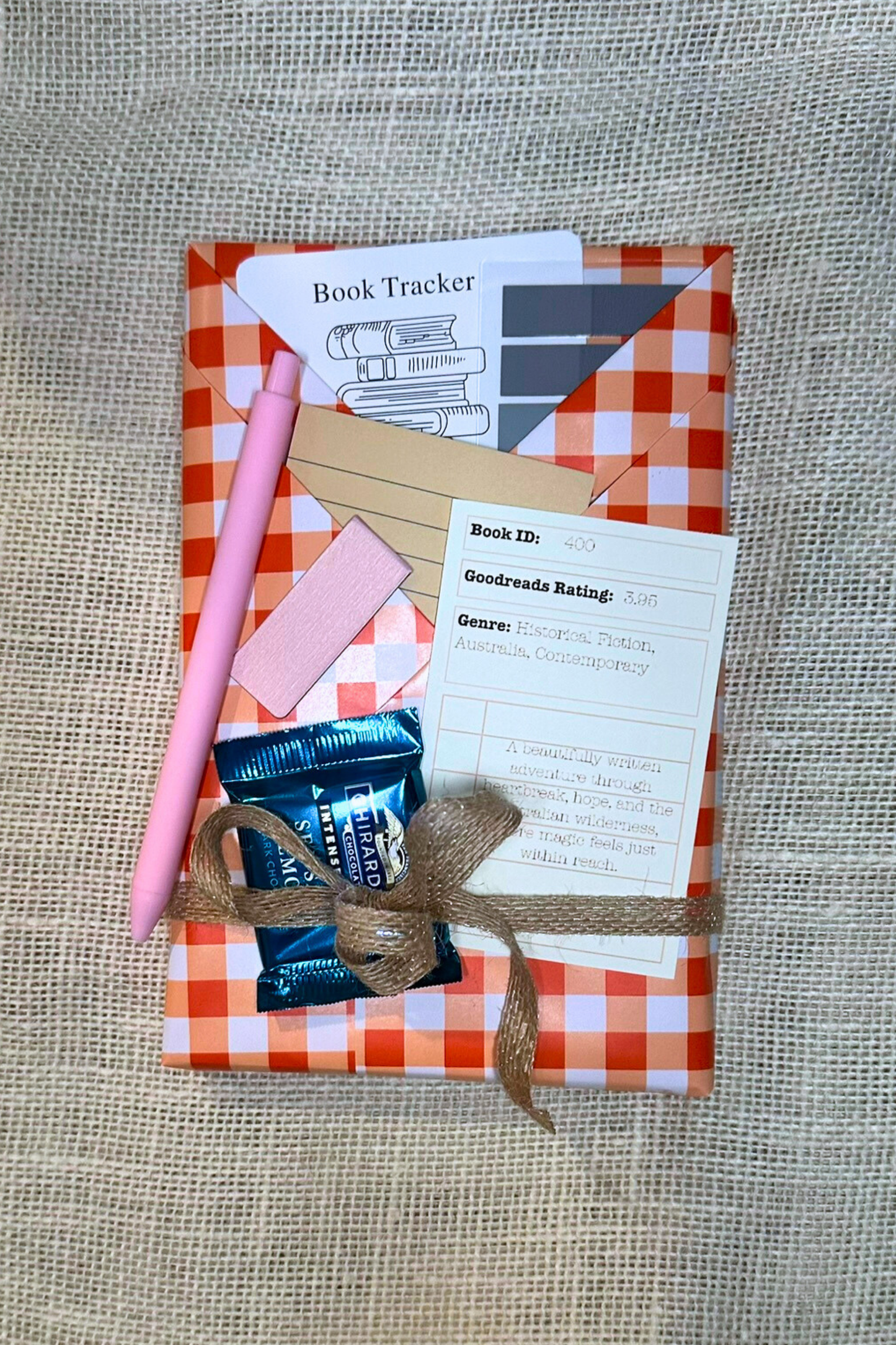 Wrapped book with pockets with book accessories inside. Including bookmark, pen, sticky notes, book tabs, and magnetic bookmark. 