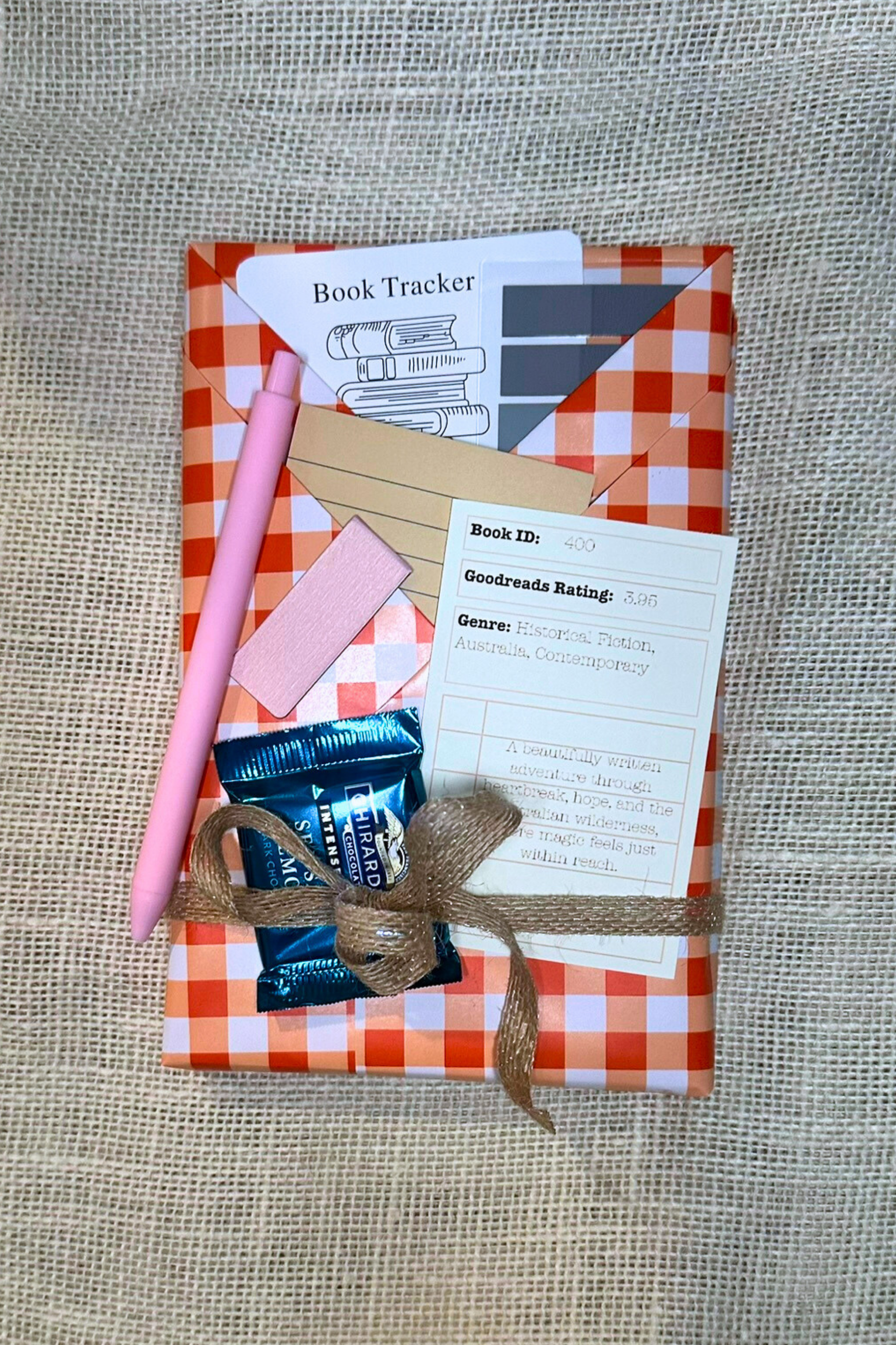 Wrapped book with pockets with book accessories inside. Including bookmark, pen, sticky notes, book tabs, and magnetic bookmark. 