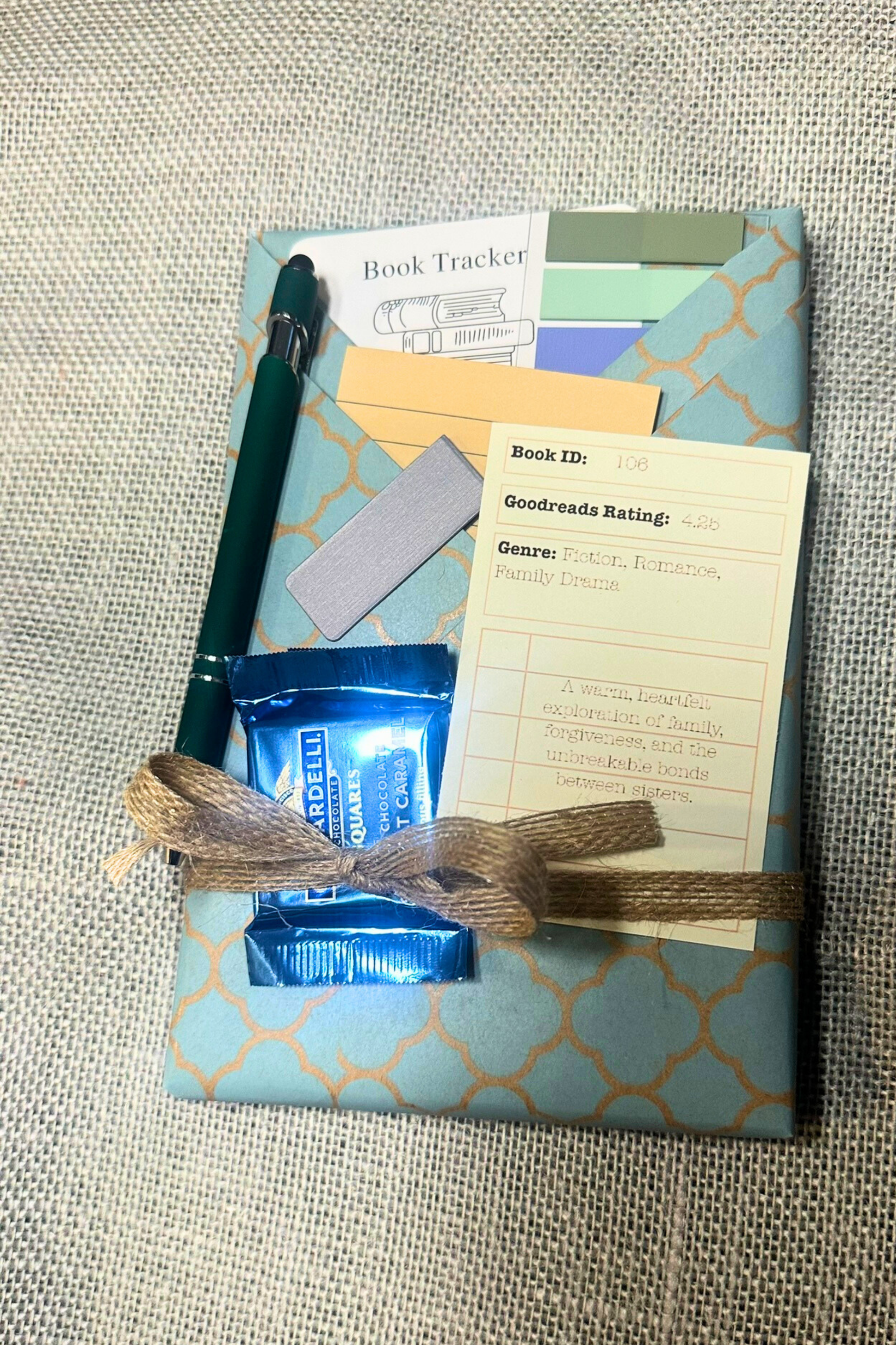 Wrapped book with pockets with book accessories inside. Including bookmark, pen, sticky notes, book tabs, and magnetic bookmark. 