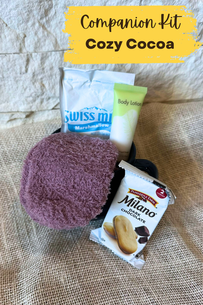 Mug with hot chocolate and cozy socks inside. Body lotion and Milano cookies around the mug. 