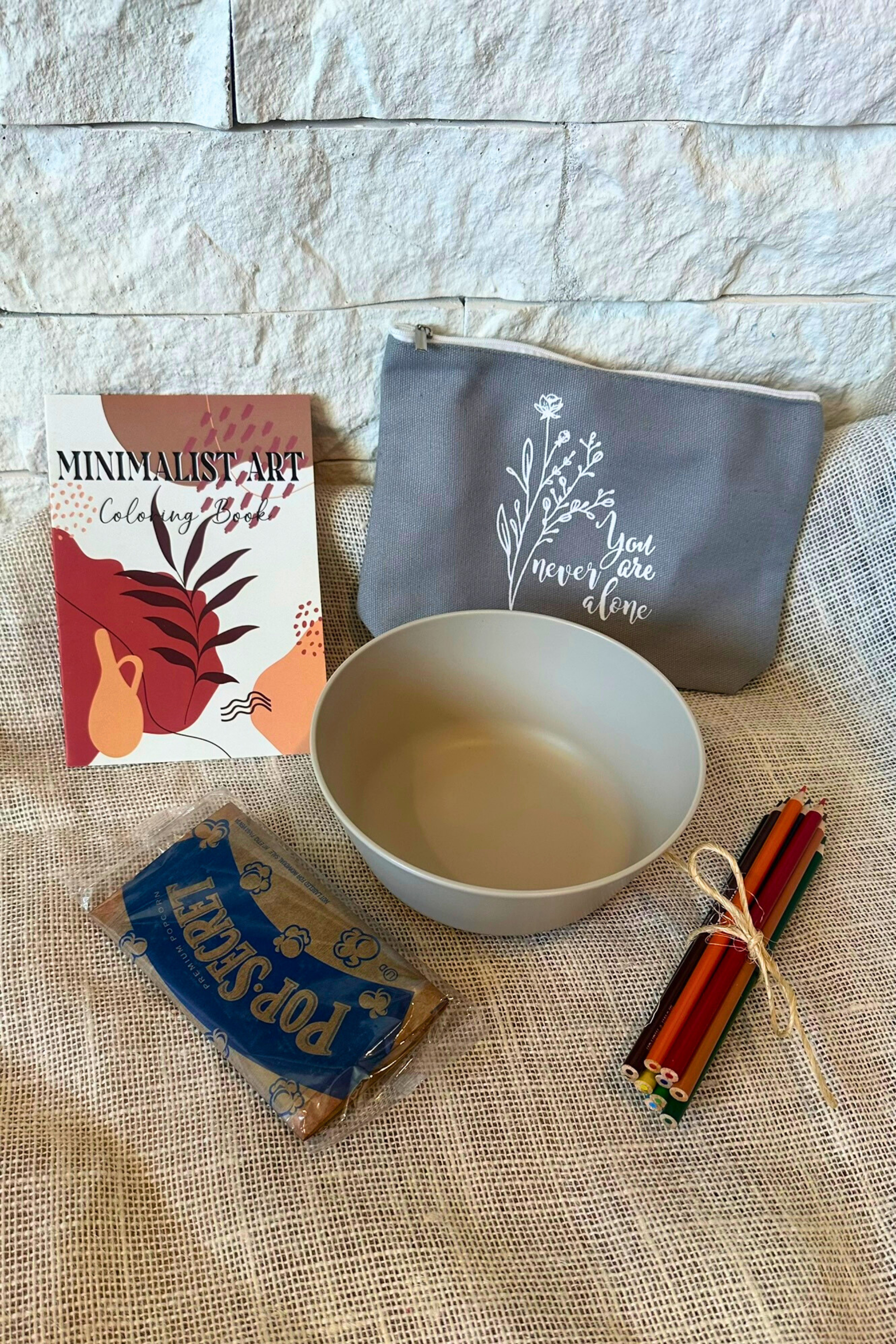 Popcorn bowl, popcorn, adult coloring book, colored pencils, and zipper pouch.