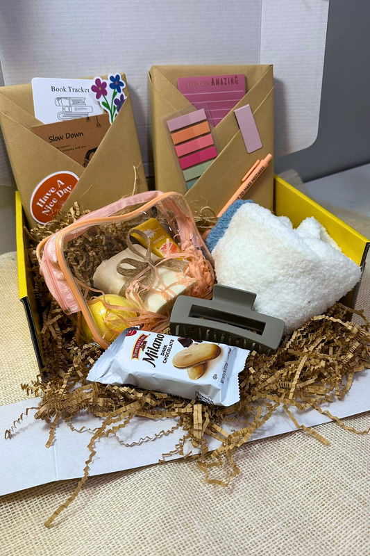 Gift box featuring blind date with a book, spa items including bath bomb, bar soap, lotion, cozy socks, and other book related items. 
